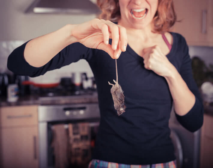 woman holding a rat in the kitchen